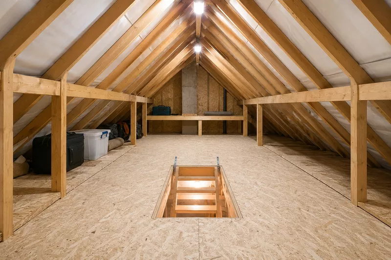 Bright, fully boarded attic with timber beams and a drop-down ladder opening